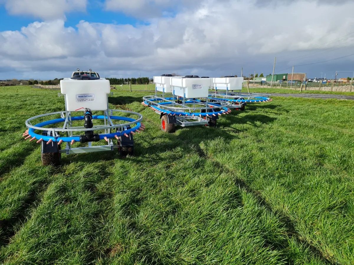 Gateswide mobile calf feeders lined up in a grass field